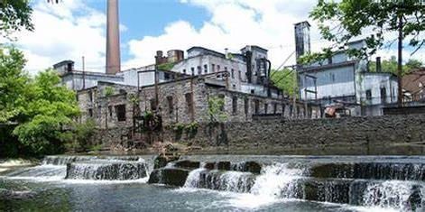 There is a waterfall in front of a large building.