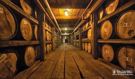 A long hallway filled with lots of wooden barrels.