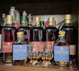 A shelf filled with bottles of whiskey and glasses.