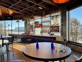 A restaurant with tables and chairs and a bar.