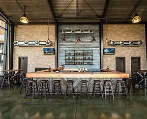 A large room with a bar and stools in it.