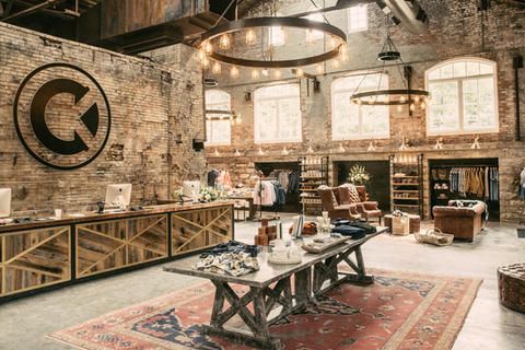 A large room with tables and chairs in it and a brick wall.