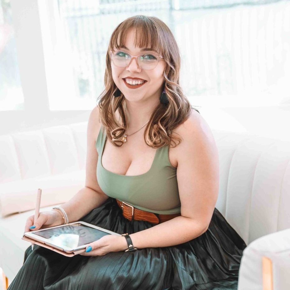 A woman wearing glasses and earrings is smiling for the camera.