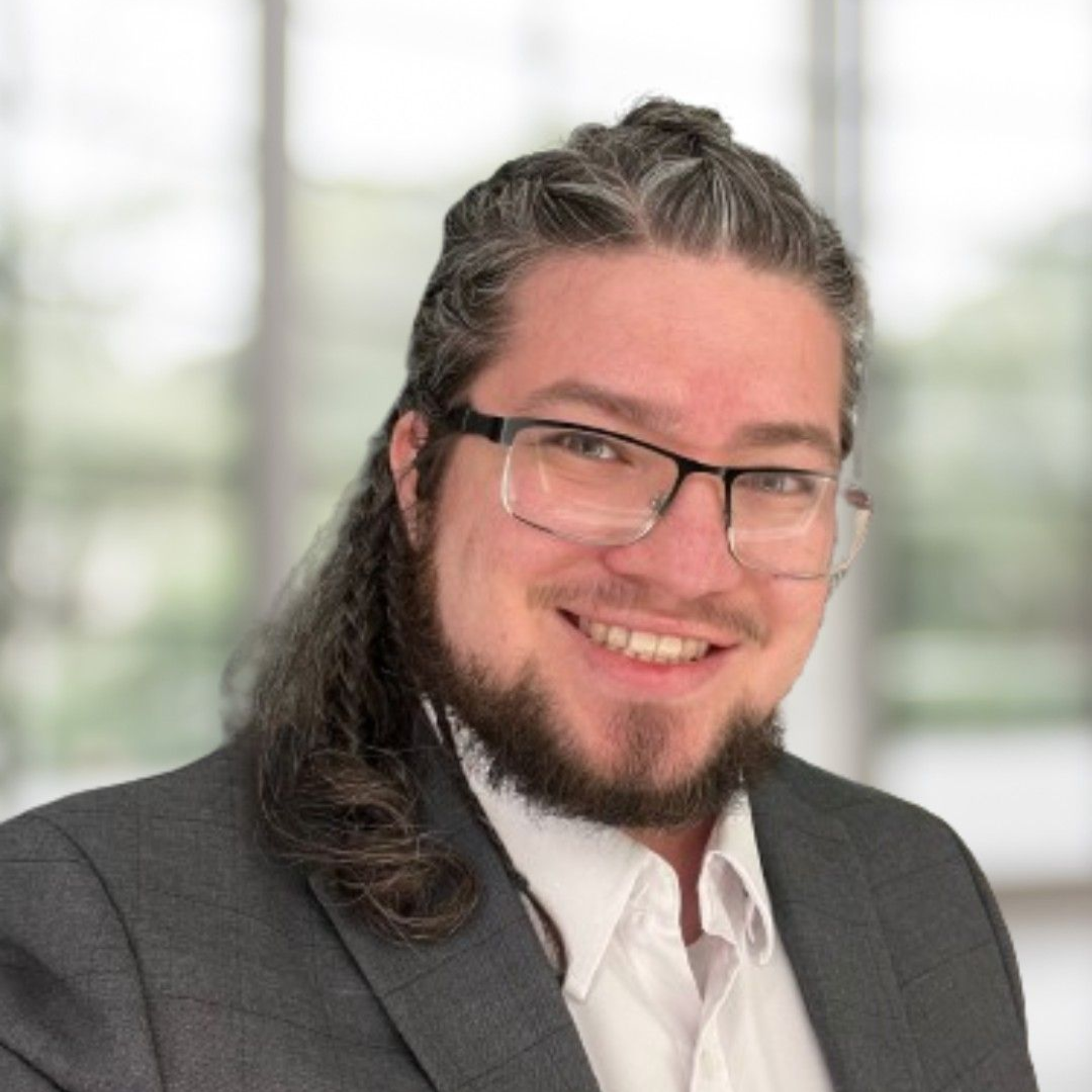 A man in a suit and tie is smiling for the camera.