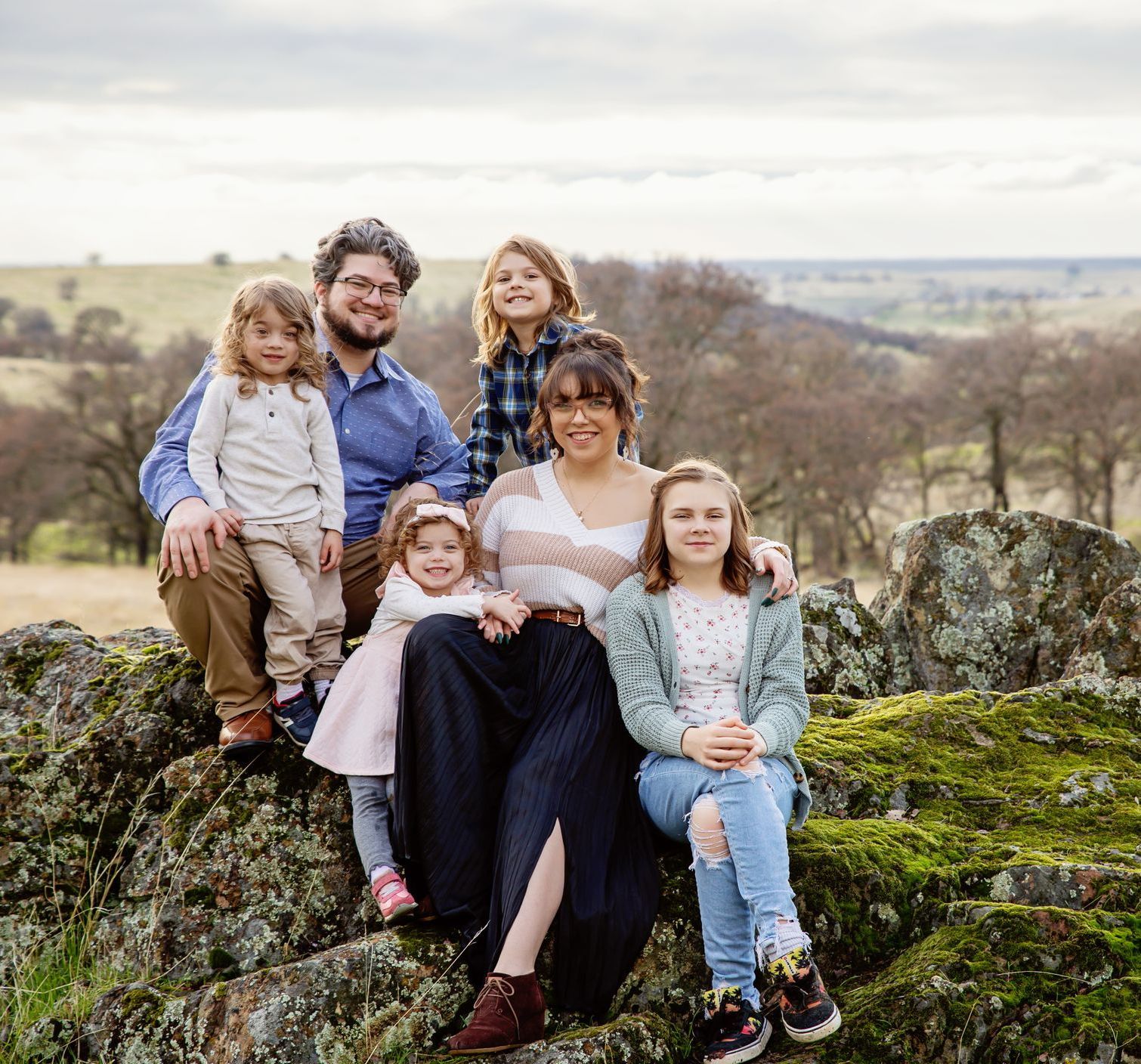 The Duron family is posing for a picture together outside.