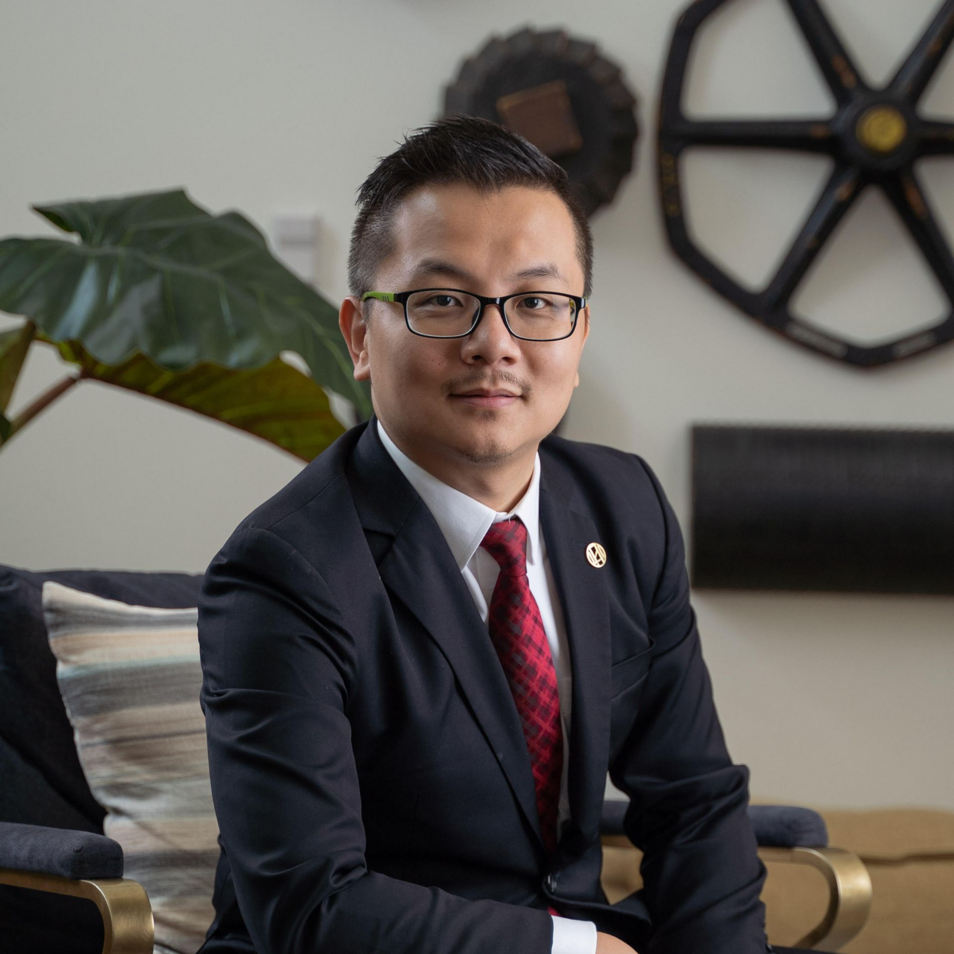 A woman wearing glasses and a purple jacket is smiling for the camera.