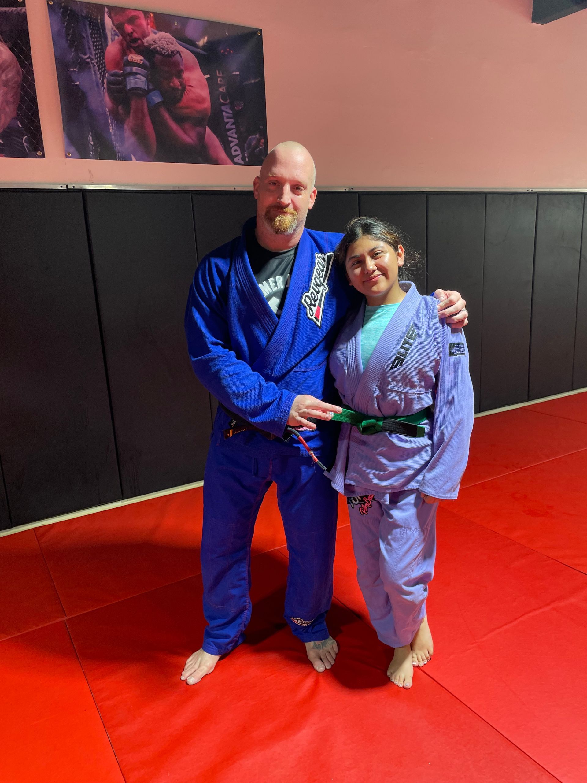 A man and a woman are posing for a picture in a gym.