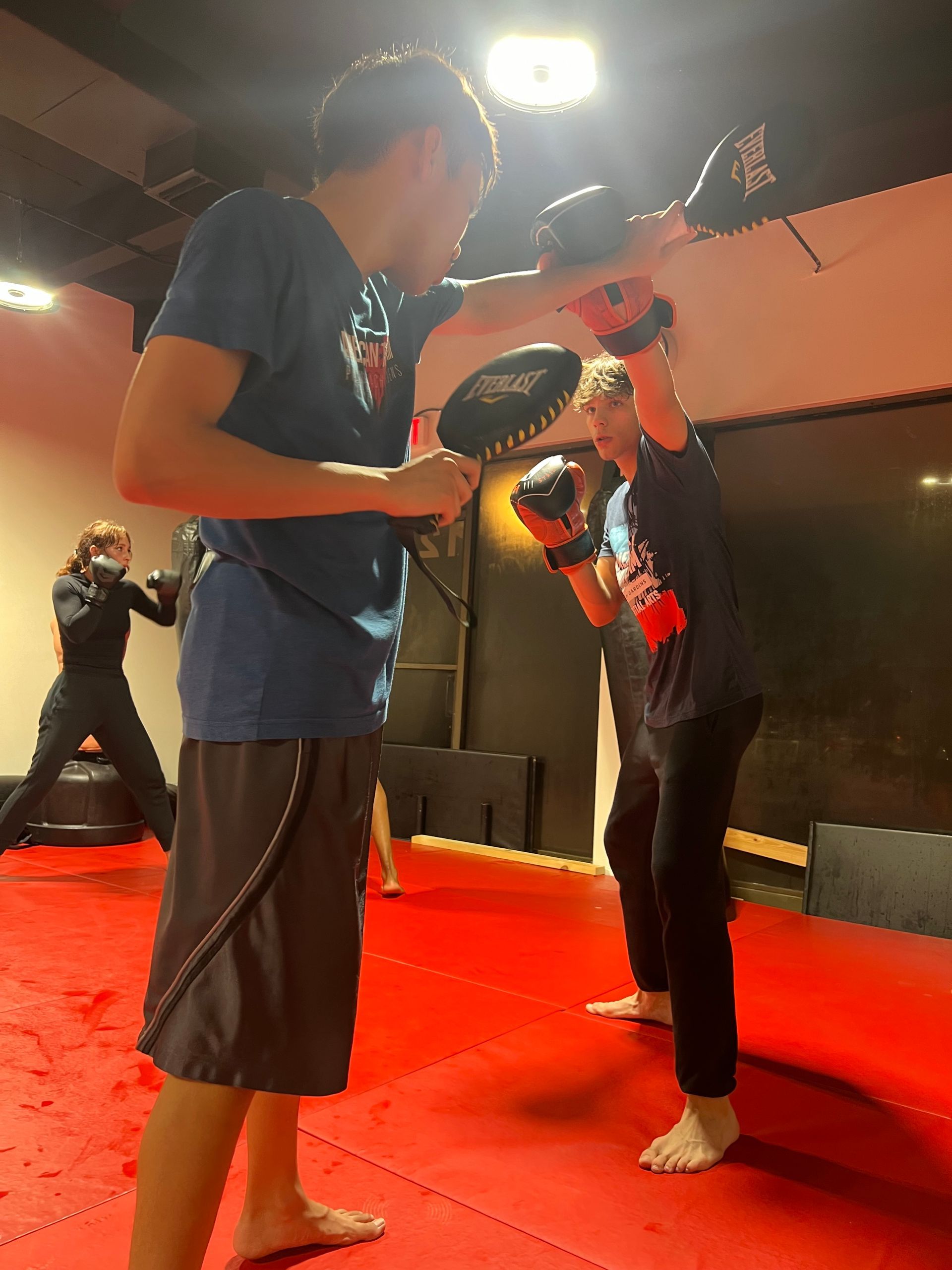 A group of people are practicing martial arts in a gym.