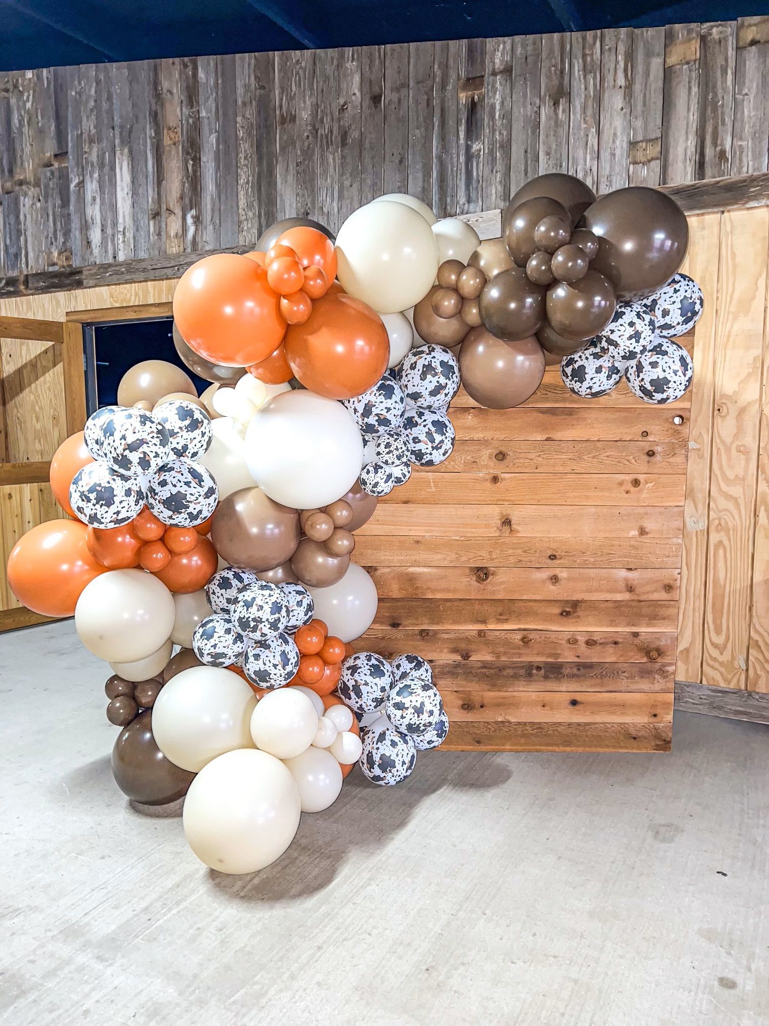 A bunch of balloons are sitting on top of a wooden wall.