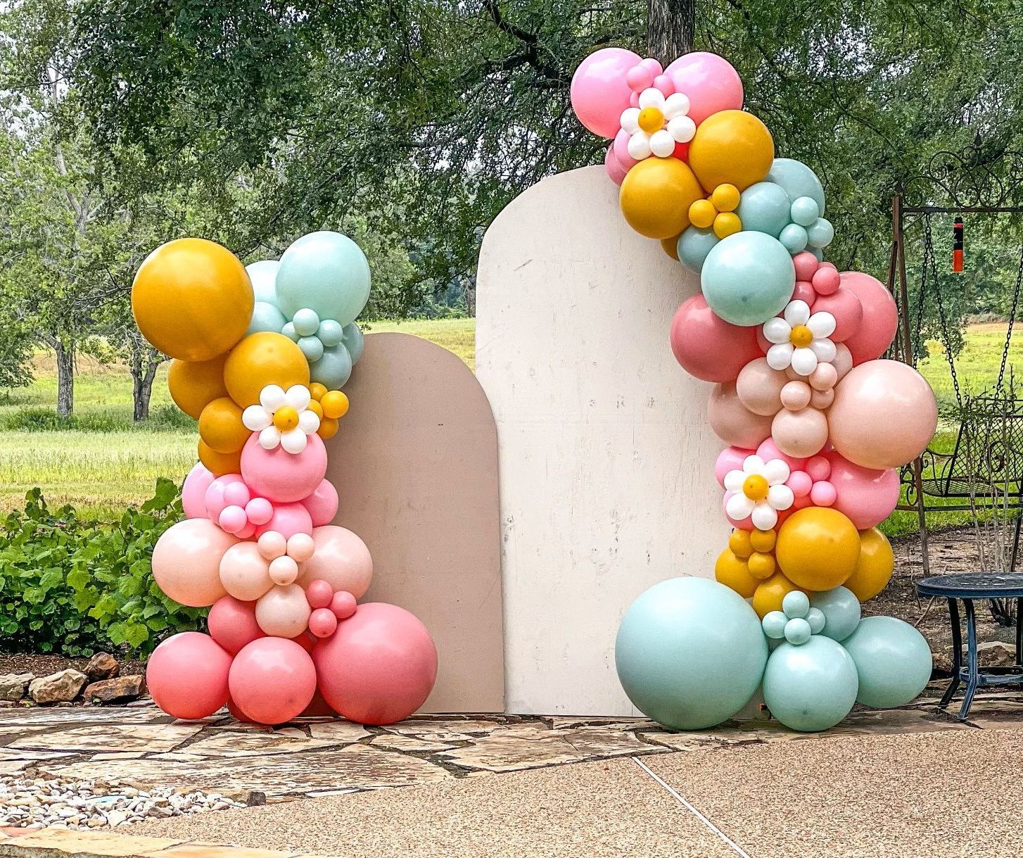 A bunch of balloons are sitting on top of each other on a gravel road.