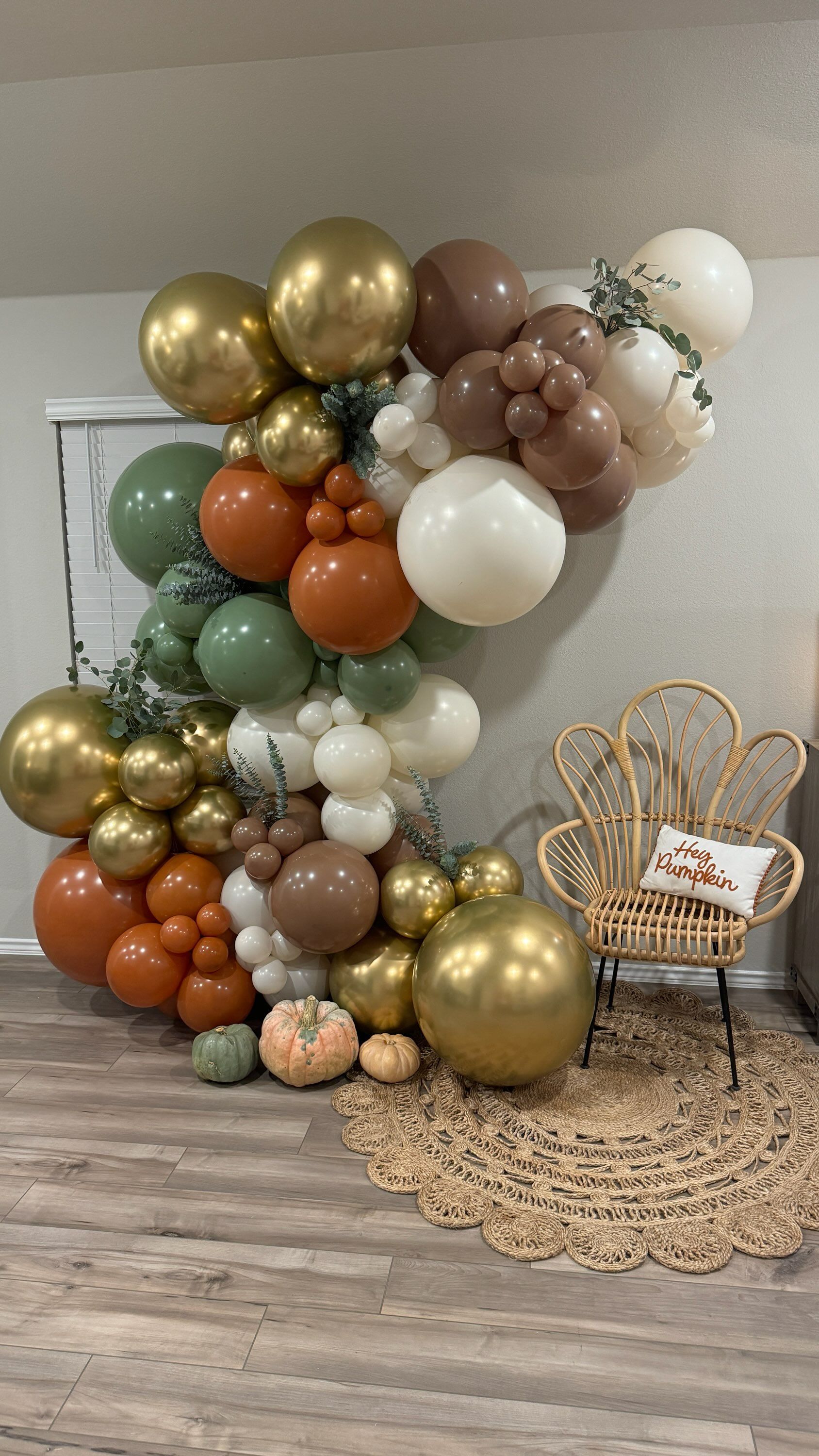 A room filled with lots of balloons and pumpkins.