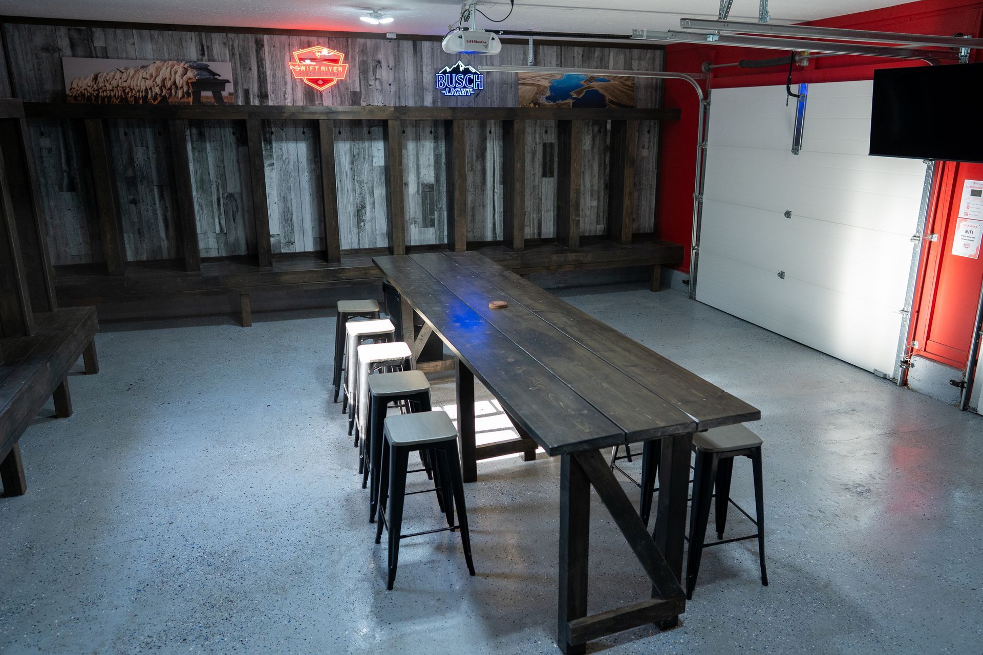 A long wooden table with stools in a garage