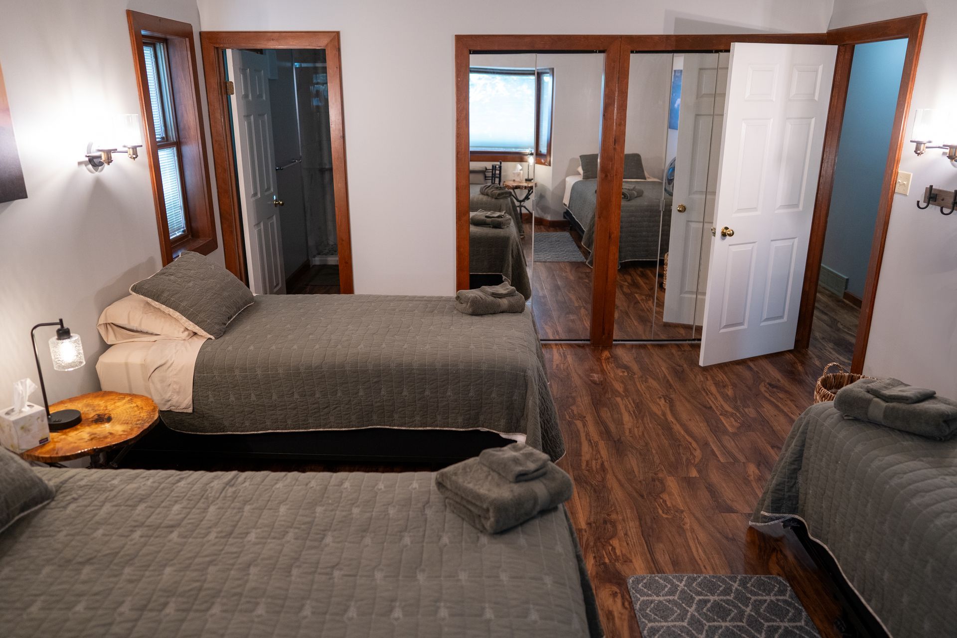 A bedroom with three beds and a closet.