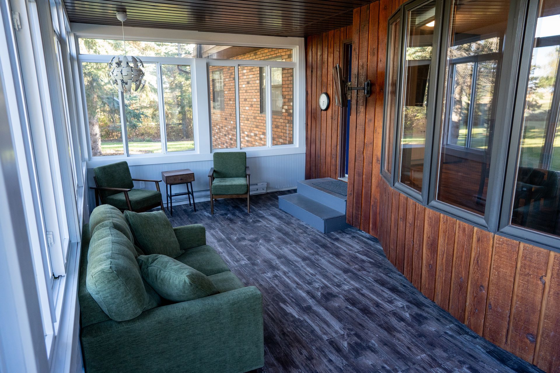 A screened in porch with a couch and chairs