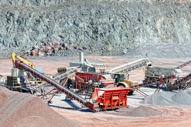 A large pile of dirt is being processed in a quarry.