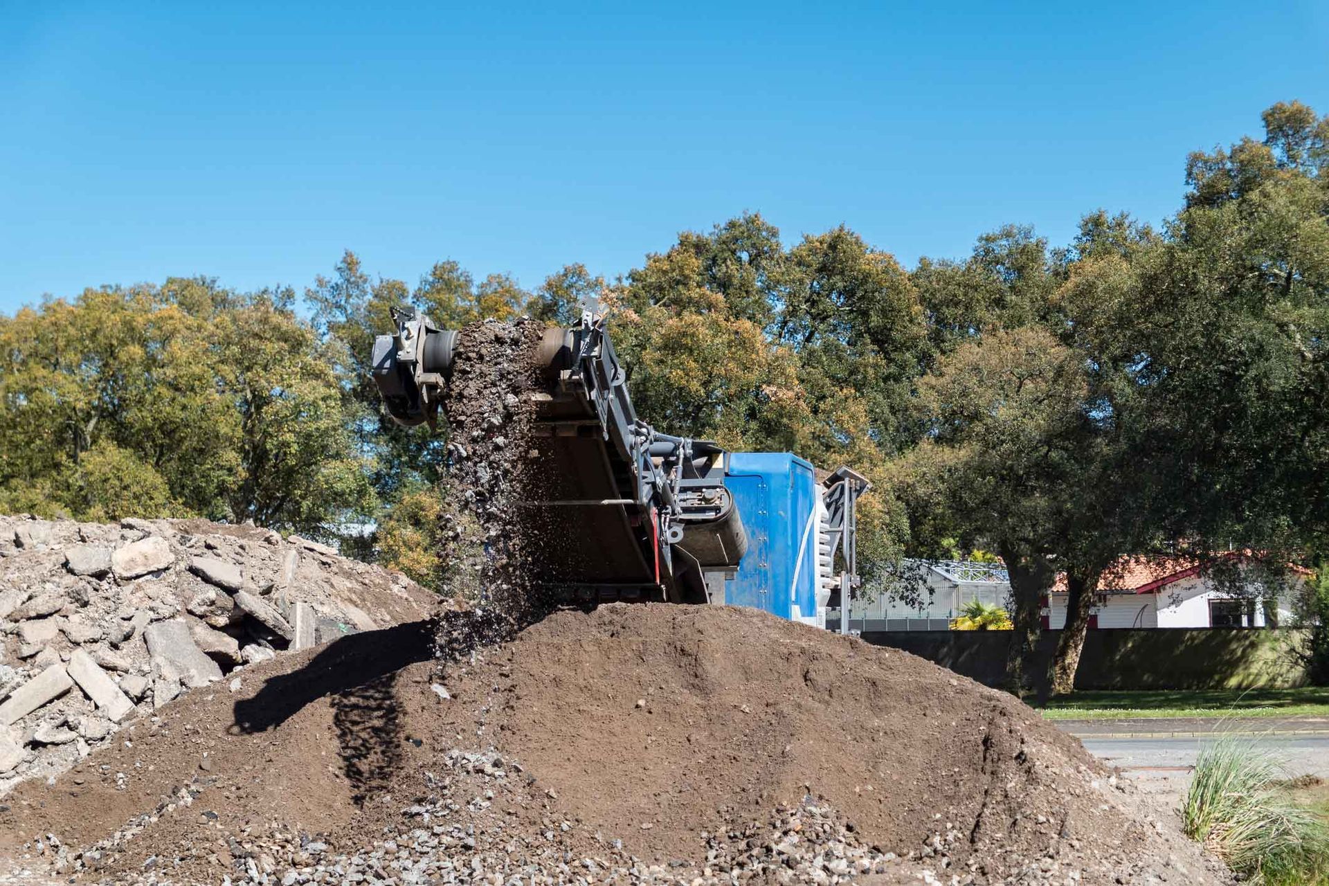 A pile of dirt is being loaded into a truck.