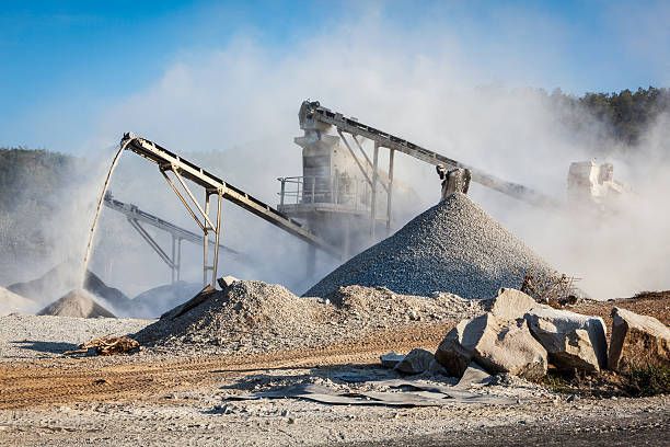 A rock quarry with a lot of rocks and dust coming out of it.