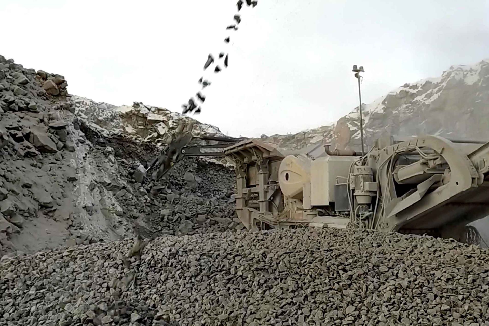 A pile of rocks is being loaded into a truck.