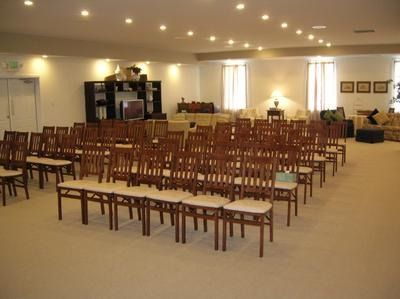 The front door of a house with a porch and plants in front of it.