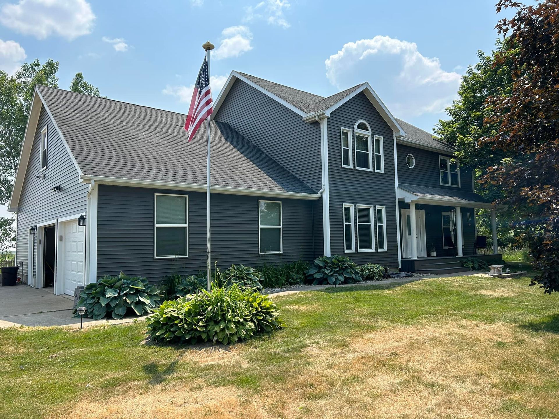 A large house with a flag pole in front of it.