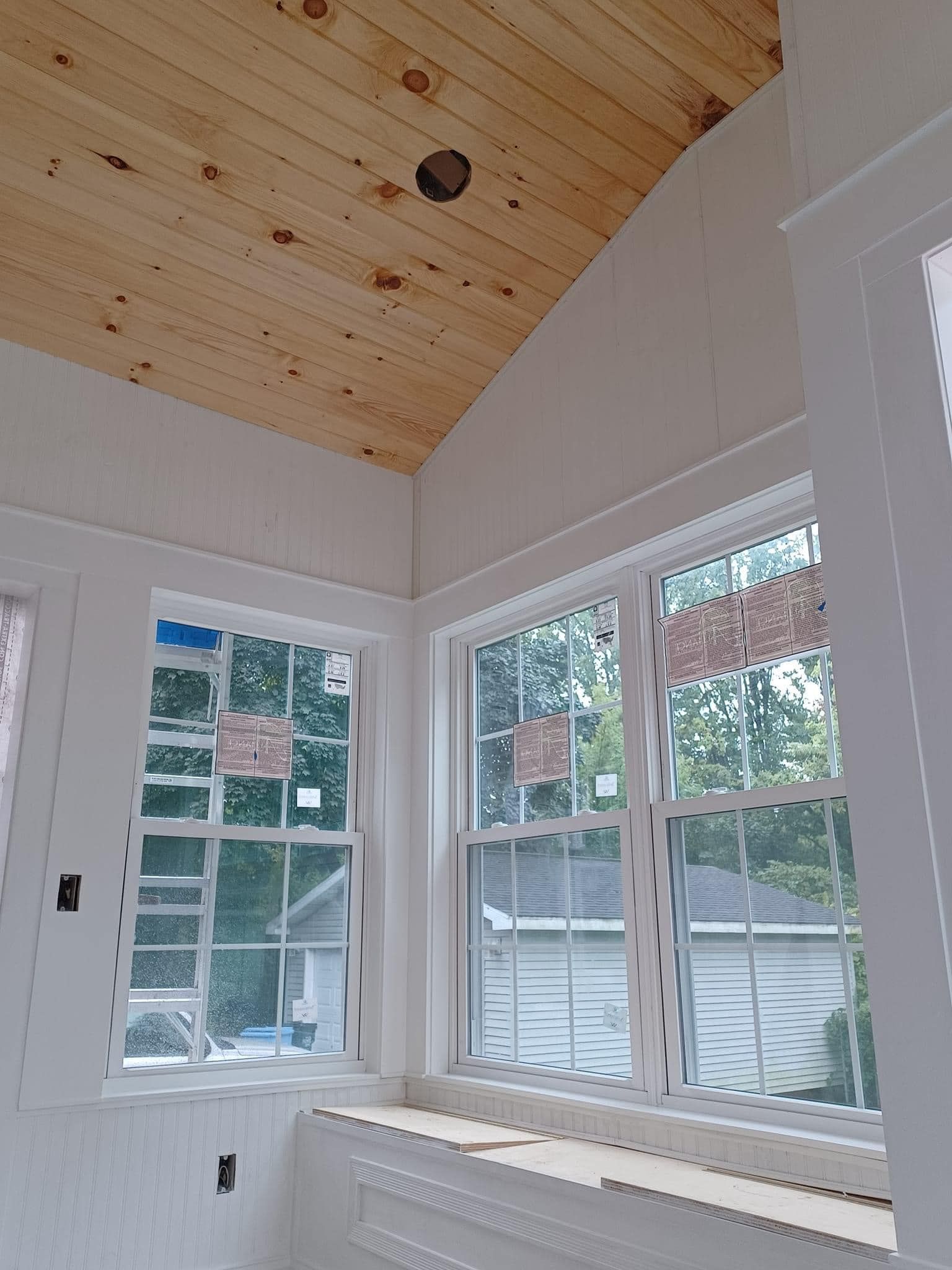 A room with a lot of windows and a wooden ceiling