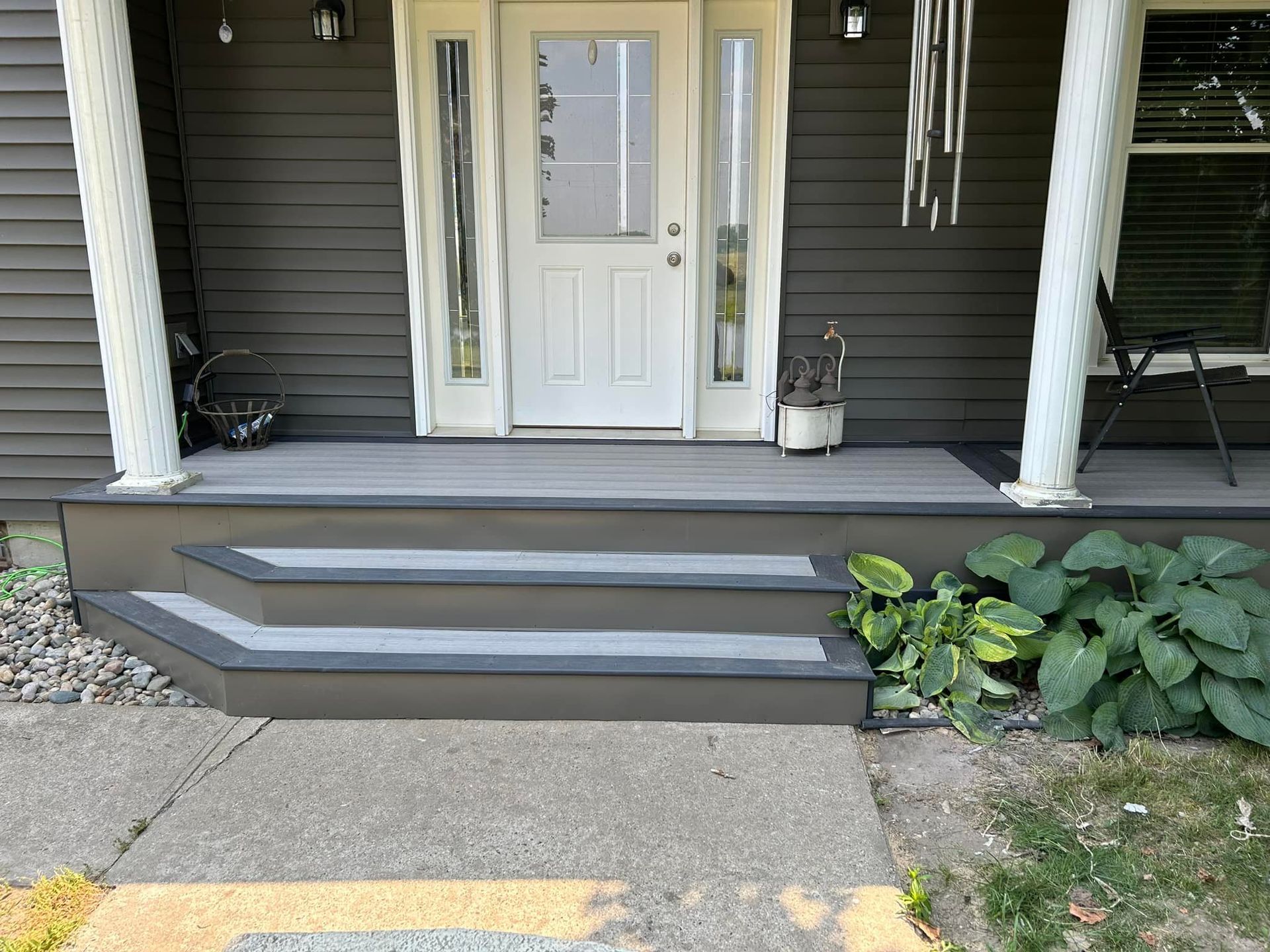 A porch with stairs leading up to the front door of a house.