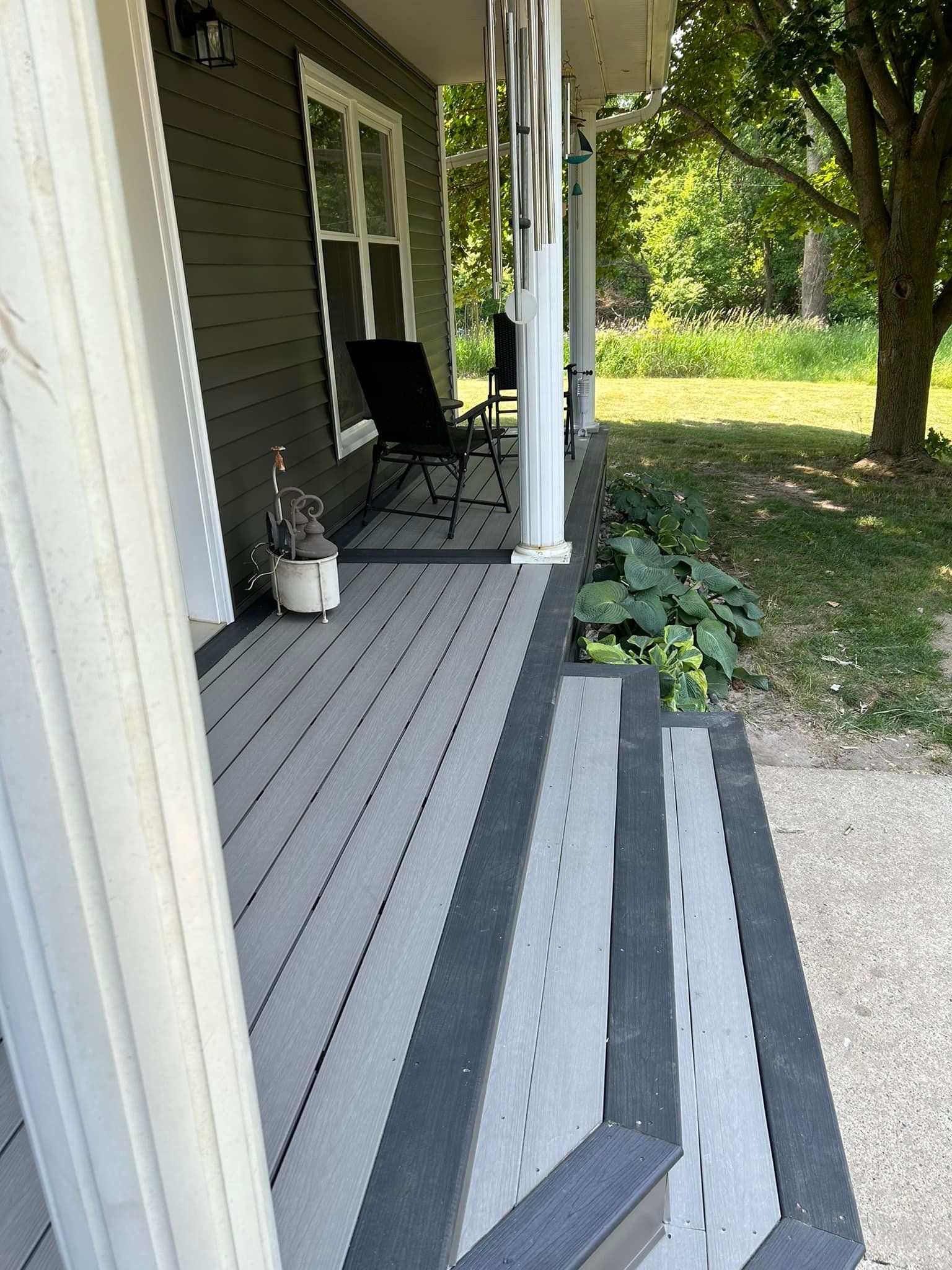 A porch with chairs and a rug on it