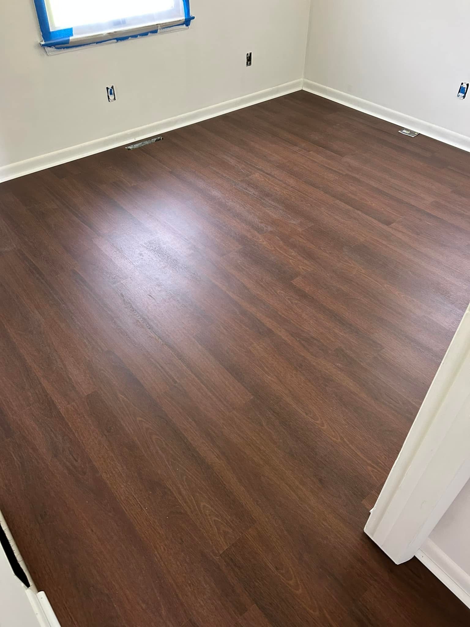 A room with a wooden floor and a window.