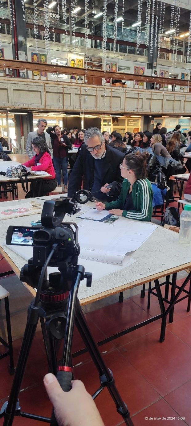 Una persona está tomando una fotografía de un grupo de personas sentadas en mesas.