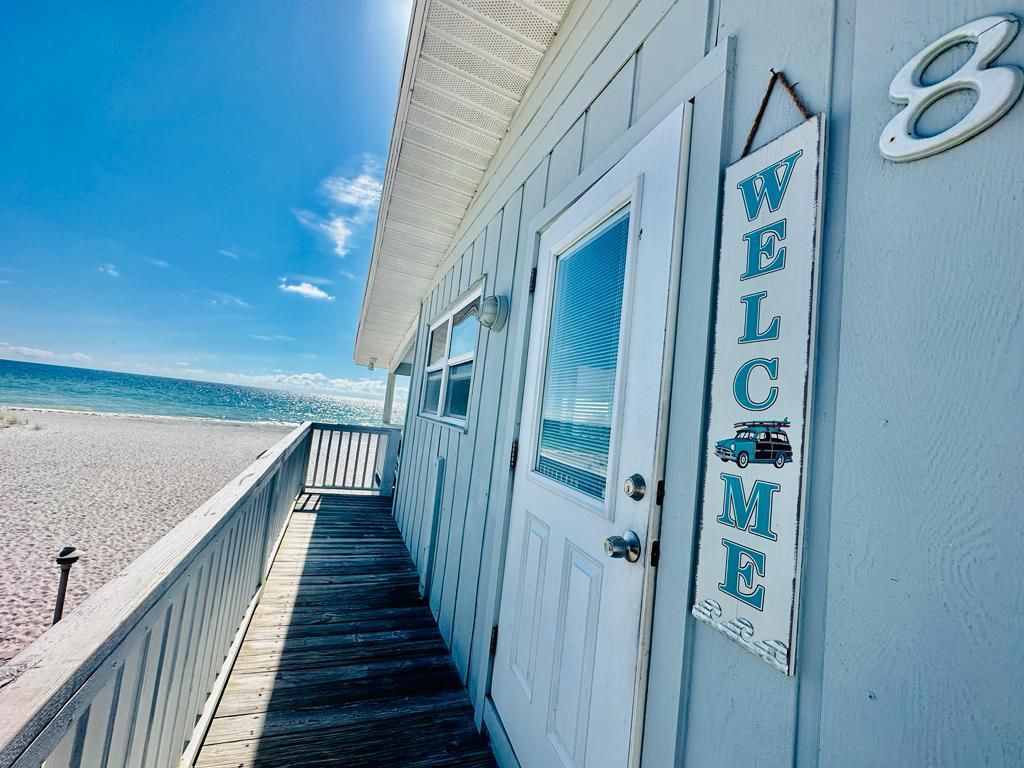 A welcome sign is hanging on the side of a building.