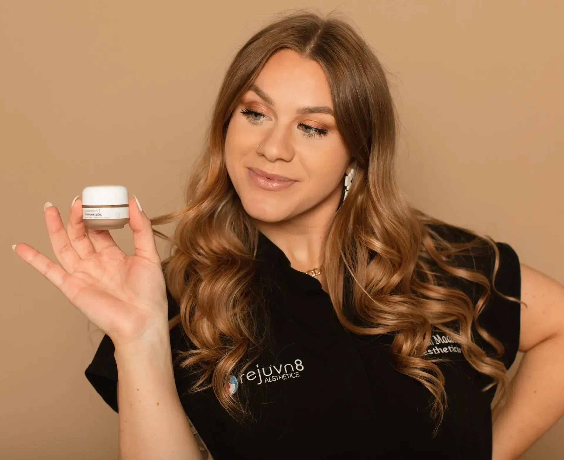Rejuvn8 Esthetician holding Cosmelan Peel bottle.