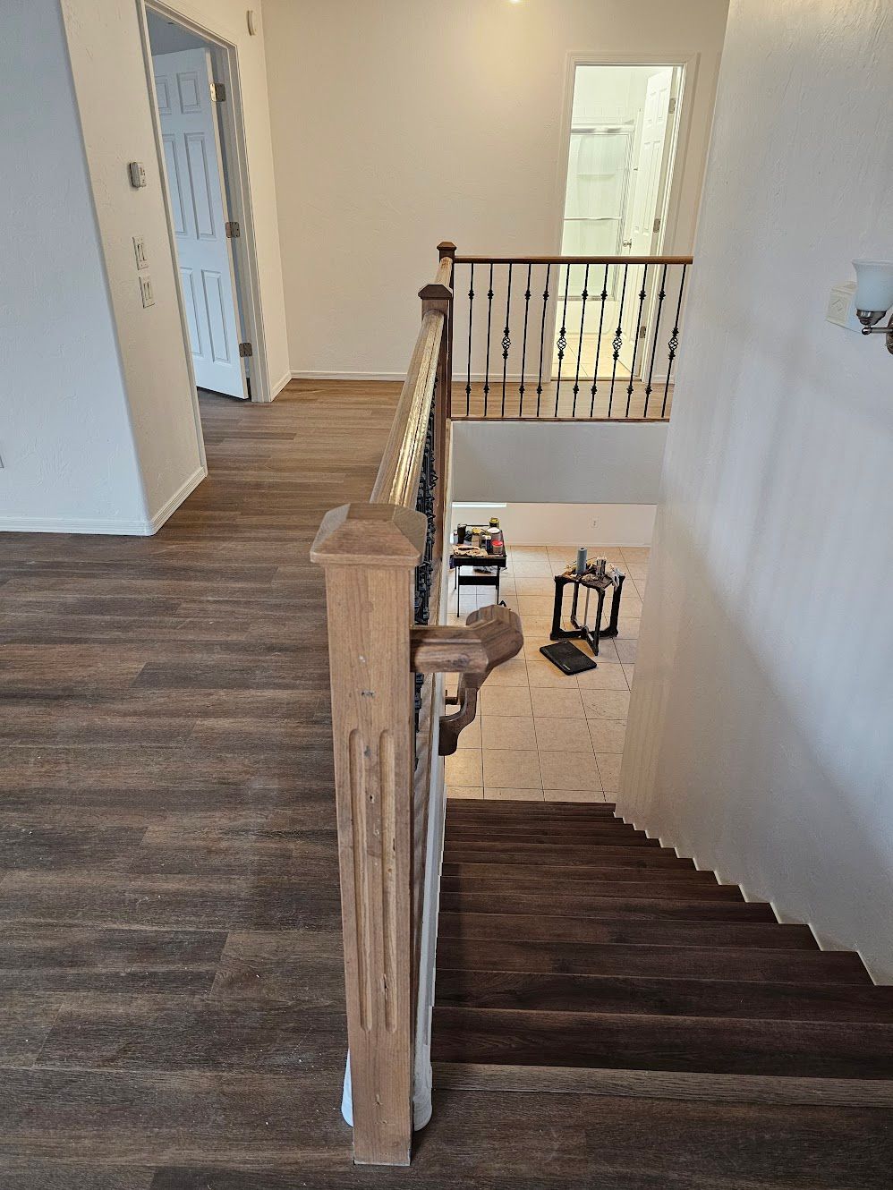 Wooden staircase with carpeted steps leading down; wooden railing and flooring.