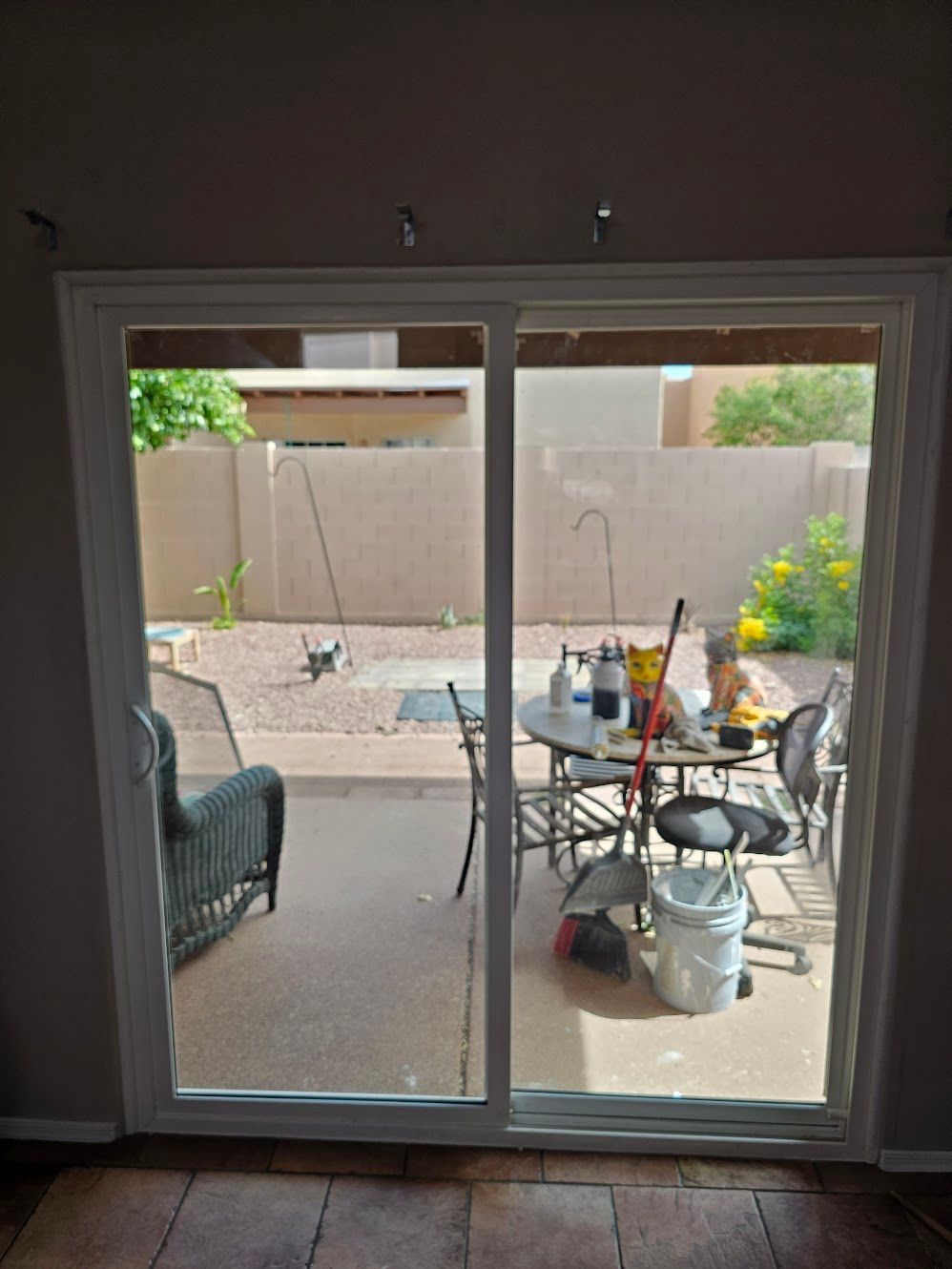 Sliding glass door looking out onto a patio with furniture and yard.