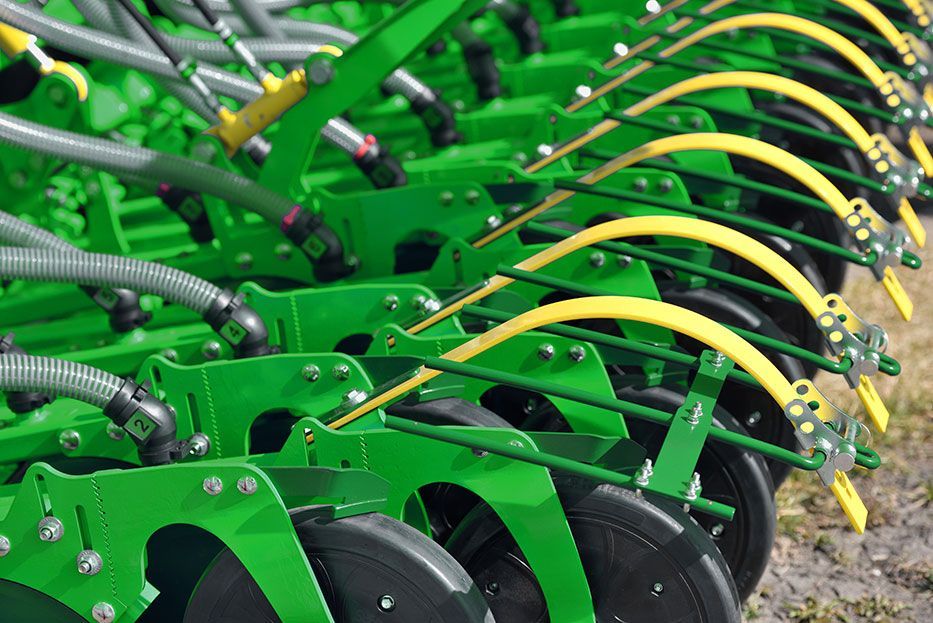 A green combine harvester is working in a field of wheat