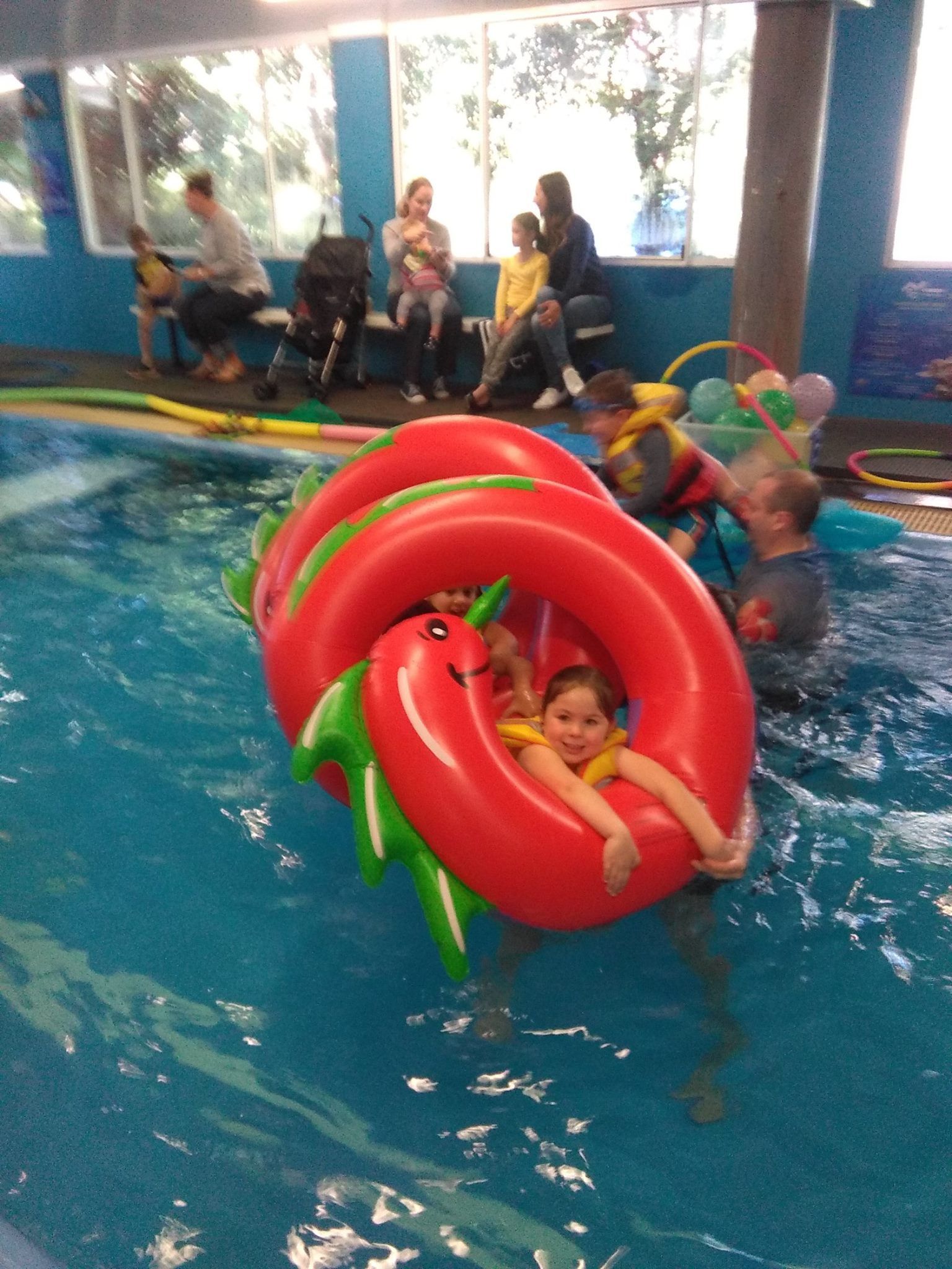 Family Watching Children Playing With Inflatible Dragon At Swim School— Swim Care Boambee in Coffs Harbour, NSW