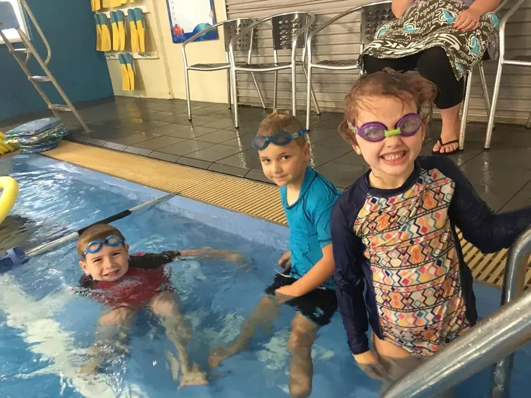 Group of children with goggles swimming at indoor swimming pool — Swim Care Boambee in Coffs Harbour, NSW
