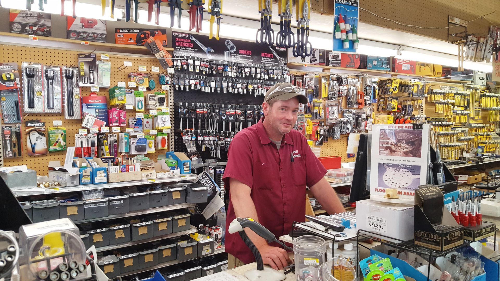 A man is standing at a counter in a hardware store.
