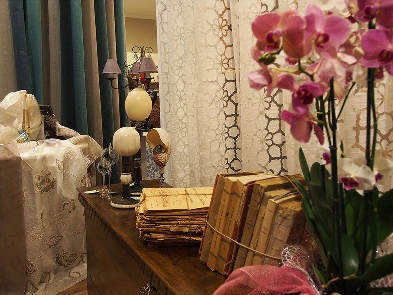 Credenza in legno con libri antichi e orchidee rosa