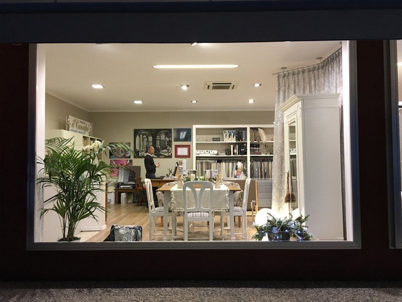 Negozio di arredamento con sedie bianche e tavolo in legno