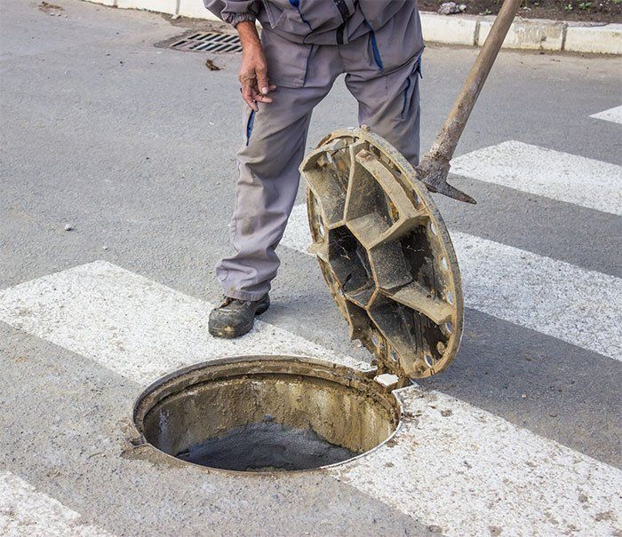 a manhole cover is open on the side of the road