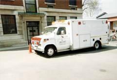 a white ambulance is parked in front of a building .