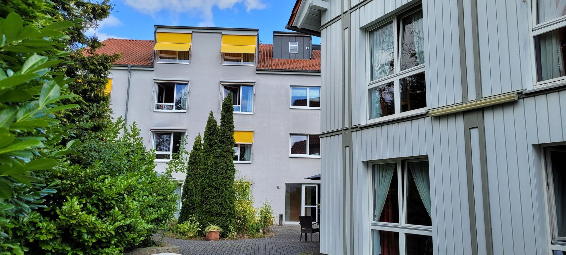 Ein Gebäude mit vielen Fenstern und Bäumen davor