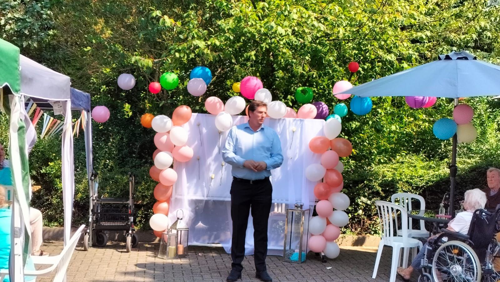 Ein Mann steht vor einer Wand aus Luftballons.