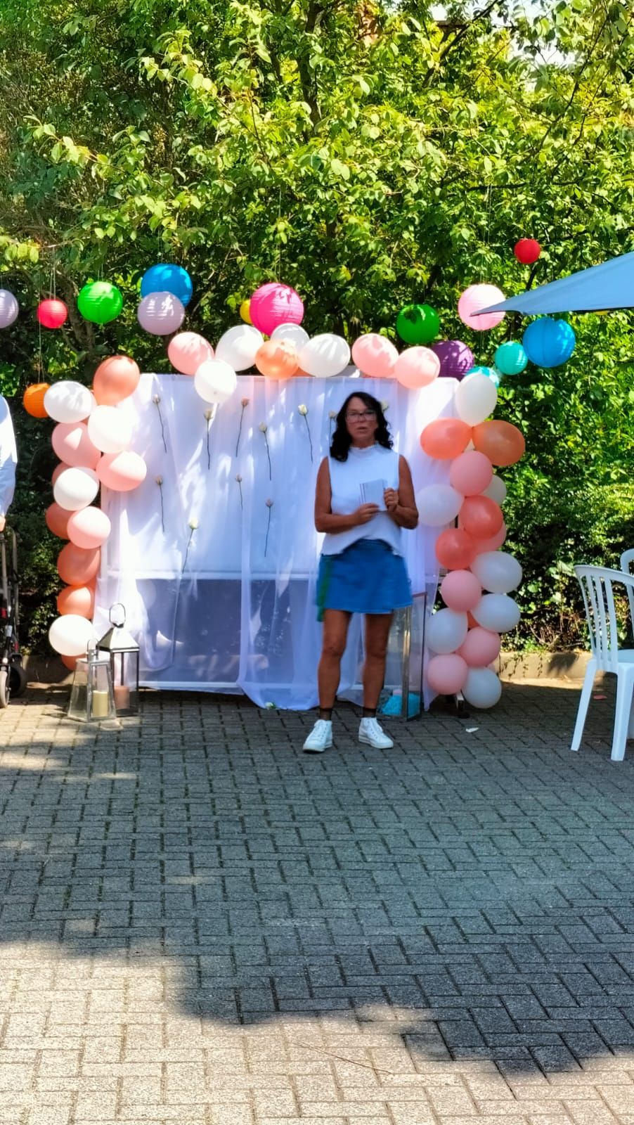 Eine Frau steht vor einer Wand, die mit Luftballons bedeckt ist.