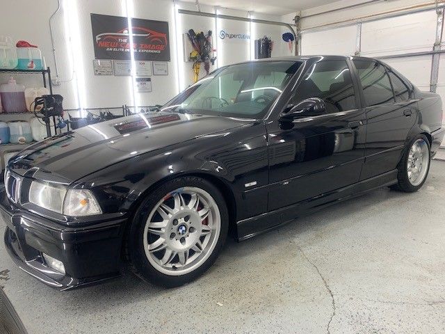 A black bmw is parked in a garage.