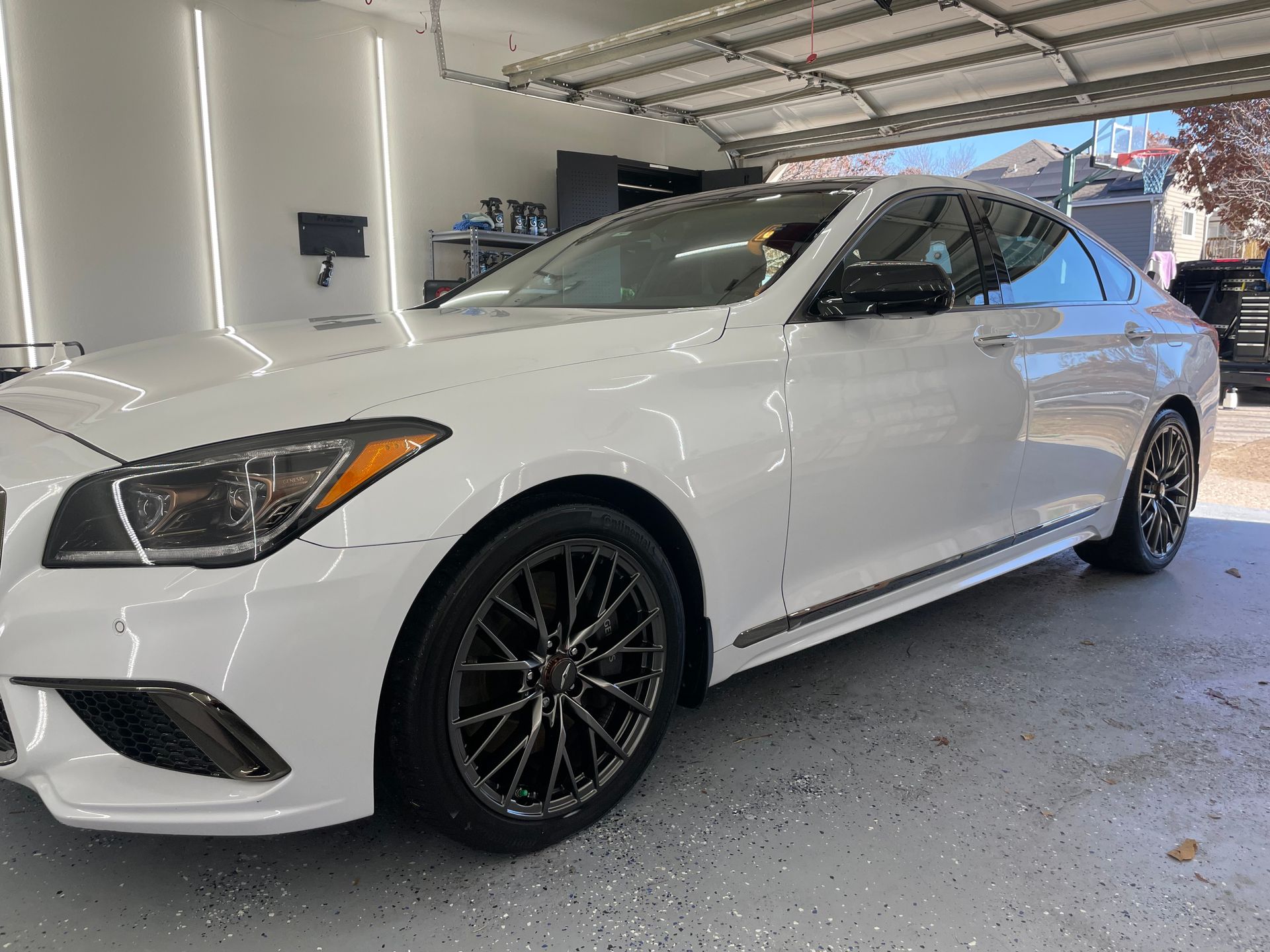 A white car is parked in a garage.
