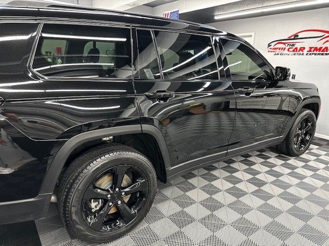 A black suv is parked on a checkered floor in a garage.