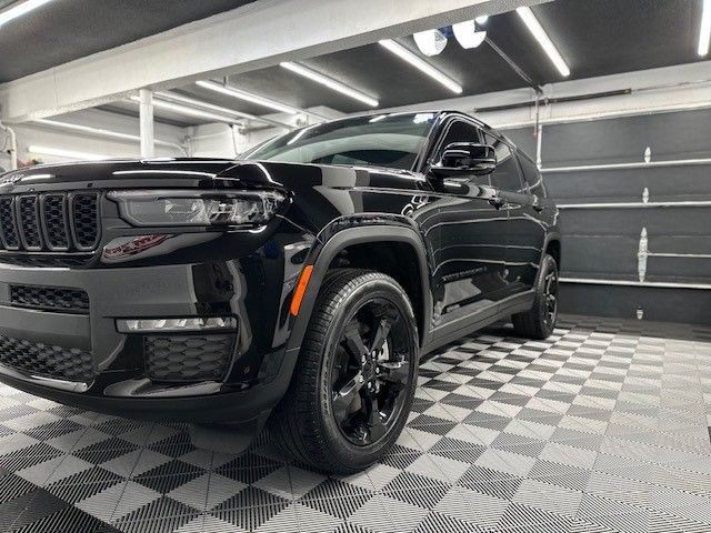 A black jeep grand cherokee is parked in a garage.