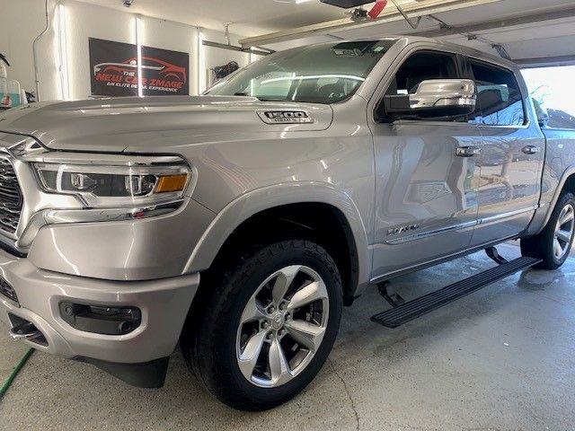 A silver ram truck is parked in a garage.