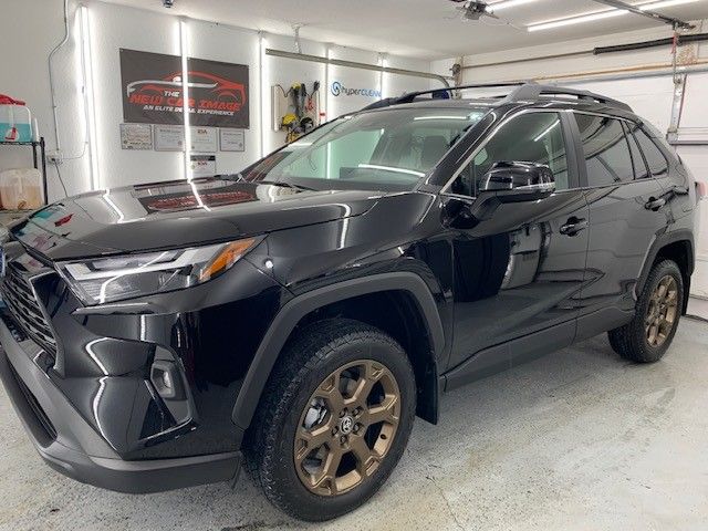 A black toyota rav4 is parked in a garage.